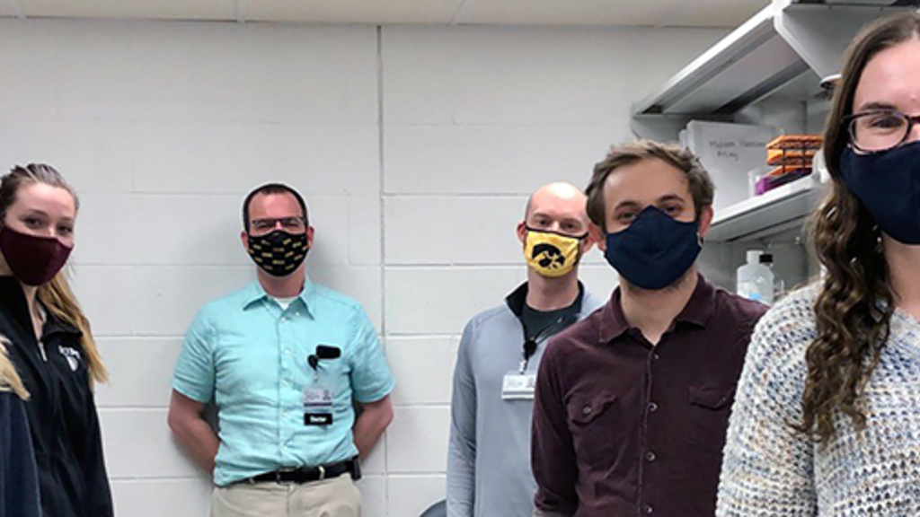 Dr. Hefti's lab members standing in a lab wearing masks